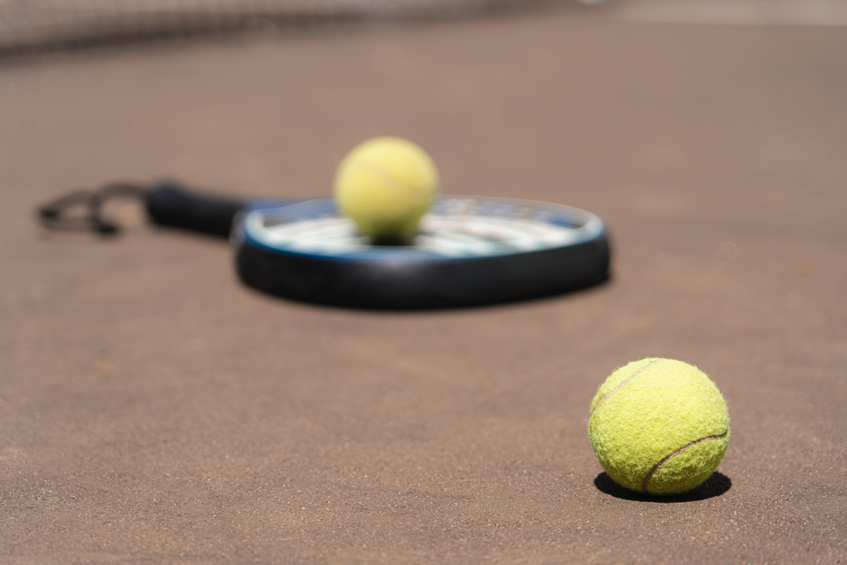 Padel balls and racket on court